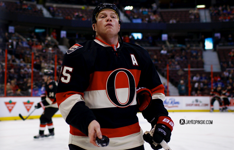 OTTAWA, CANADA - November 28: Ottawa Senators Right Wing Chris Neil (25) [1585] tosses a puck to a young fan before a  game between the Canucks and Senators at the Canadian Tire Centre on November 28, 2013 in Ottawa, Ontario, Canada. ***** Editorial Use Only ***** Jay Kopinski - Icon SMI