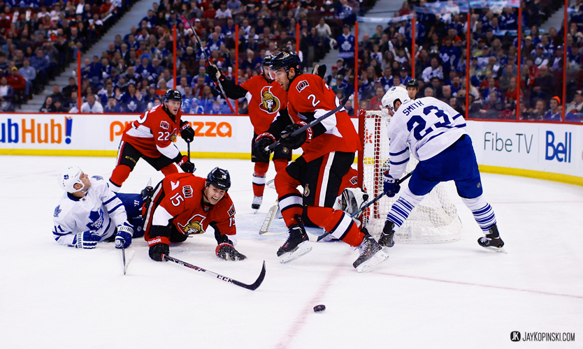 OTTAWA, CANADA - December 07:Ottawa Senators Center Zack Smith (15) [6906] is tripped up by Toronto Maple Leafs Center Jay McClement (11) [2518]; Ottawa Senators Defenceman Erik Karlsson (65) [6758] wanting a penalty during a  game between the Maple Leafs and Senators at the Canadian Tire Centre on December 07, 2013 in Ottawa, Ontario, Canada. ***** Editorial Use Only *****Jay Kopinski - Icon/SMI